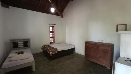 a room with two beds and a dresser in it at Ninho da Águia - Chalés in Poços de Caldas
