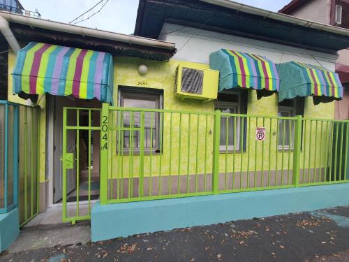 a yellow house with a fence and umbrellas at Artsy fully equipped 2 bedrooms House all to yourself! in Bucharest