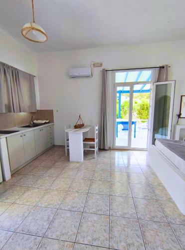 a large room with a kitchen and a table at Venetos Studios in Livadi Astypalaias