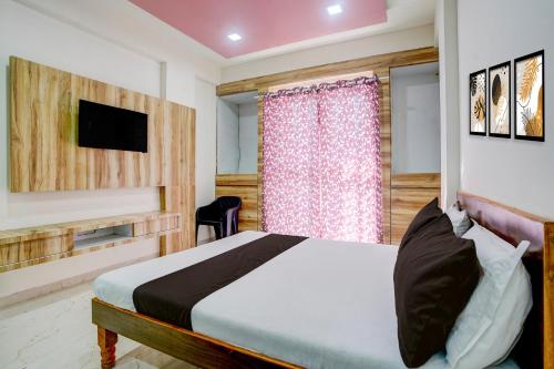 Una televisión o centro de entretenimiento en Hotel O Saptashrungi Lodging
