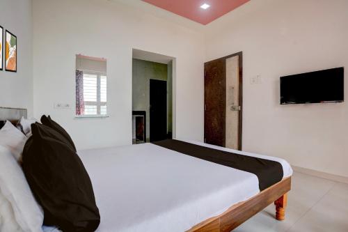 Una televisión o centro de entretenimiento en Hotel O Saptashrungi Lodging