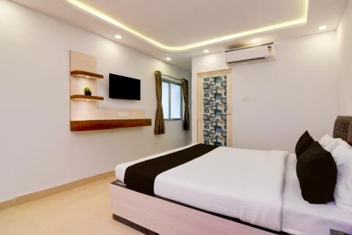 a bedroom with a bed and a tv on the wall at Hotel O Acroview in Ballygunge