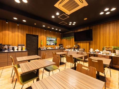 a restaurant with wooden walls and tables and a kitchen at APA Hotel Hakataeki Chikushiguchi in Fukuoka