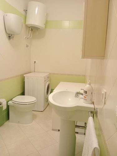 a white bathroom with a toilet and a sink at Costa degli Dei apartment in Pizzo