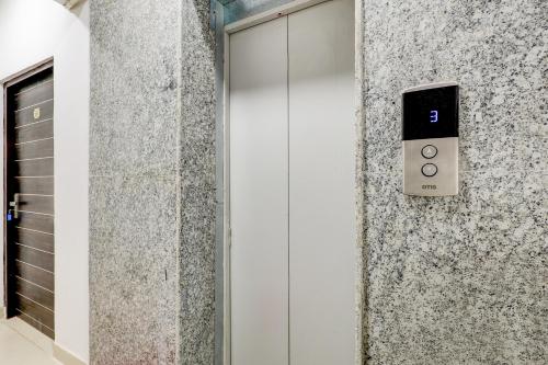 a door with a thermostat on a wall at Collection O Sector 7 Dwarka Formerly Aakarshan Residency in Dwarka, New Delhi
