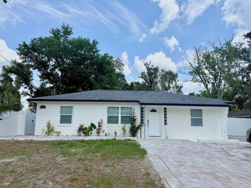 a white house with a garage at House Aurora next to Bush Gardens in Tampa