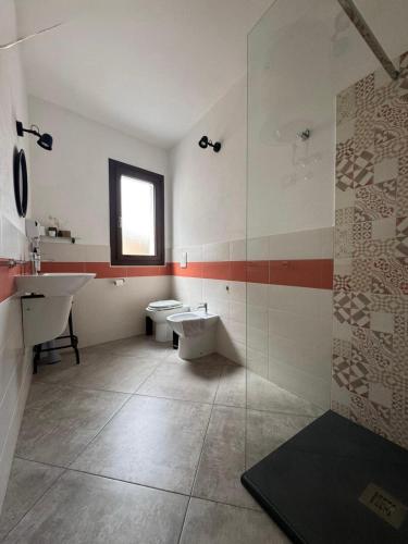 a bathroom with a sink and a toilet and a shower at L'obiettivo in Assemini