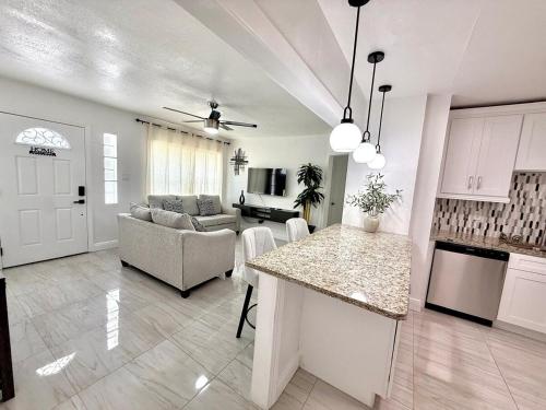 a kitchen and living room with a couch and a table at House Aurora next to Bush Gardens in Tampa