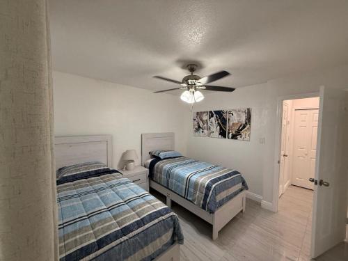a bedroom with two beds and a ceiling fan at House Aurora next to Bush Gardens in Tampa