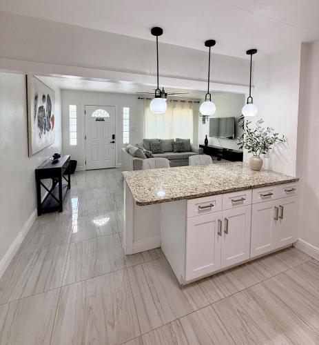 a kitchen with a counter and a living room at House Aurora next to Bush Gardens in Tampa