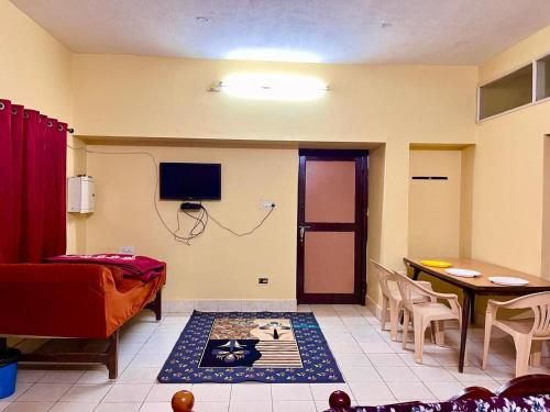 a room with a bed and a table and a television at Jungle retreat waterfalls in Kodaikānāl