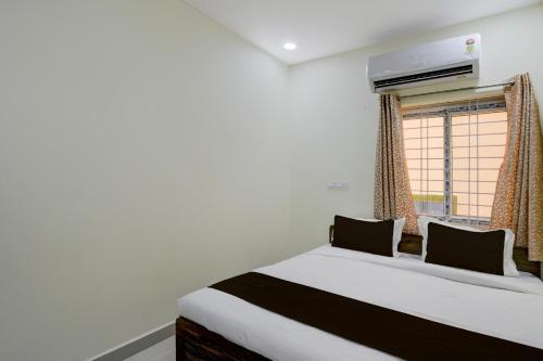 a bedroom with a large bed and a window at Hotel O The Dream Inn in Pedda Ambarpet