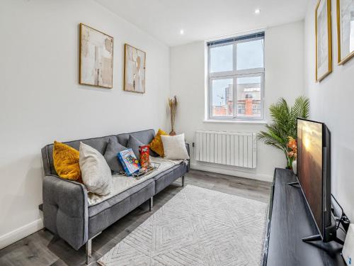 a living room with a couch and a tv at The Calm Quarters - City Centre 2BR 2BA in Leicester