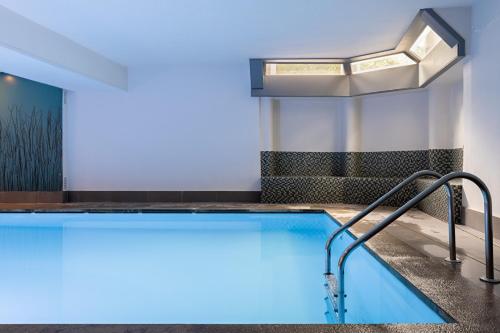 una piscina en una habitación de hotel con iluminación azul en Hotel Cavalli - Winterwonderland, en Blankenberge