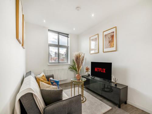 a living room with a couch and a tv at The Calm Quarters - City Centre 2BR 2BA in Leicester