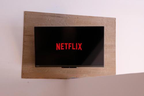 een televisie met het netflix-teken op een muur bij Suite con spa privata disponibile su richiesta in Maso
