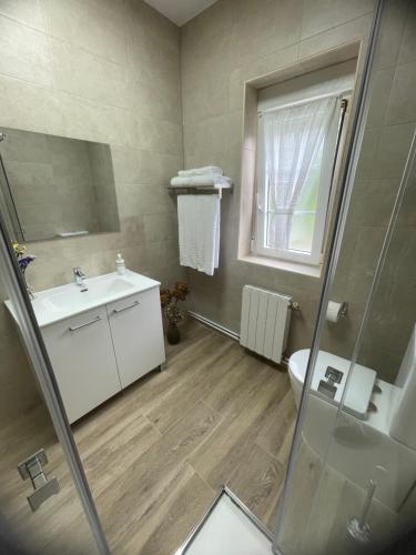 une salle de bain avec un lavabo et des toilettes et une fenêtre dans l'établissement O Fogar da Fonte, à Cee
