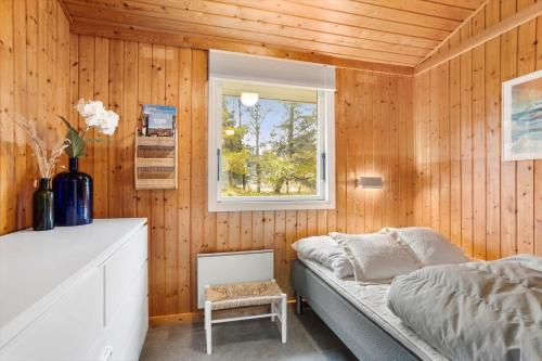ein kleines Schlafzimmer mit einem Bett und einem Fenster in der Unterkunft TV1689 Strandby - Klitmarken 4 in Strandby