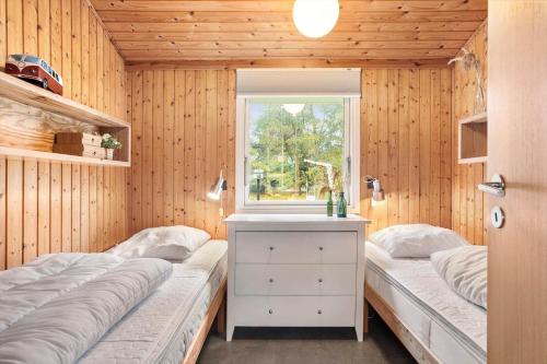 ein Schlafzimmer mit zwei Betten und einem Fenster in der Unterkunft TV1689 Strandby - Klitmarken 4 in Strandby