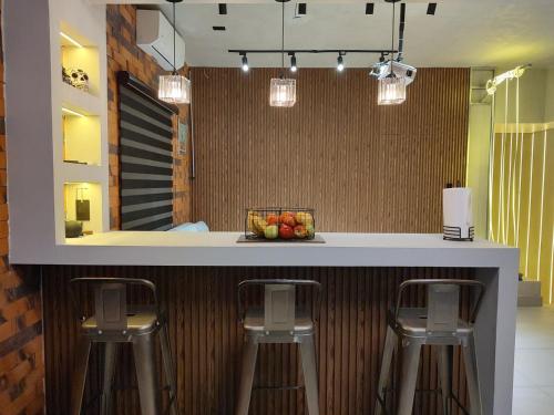 a kitchen with two bar stools and a counter at Amber Apartment at Downtown in Chihuahua