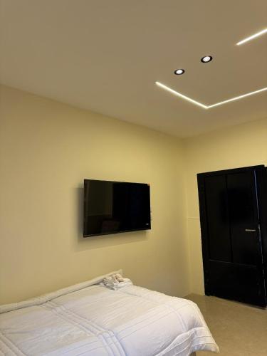 ein Schlafzimmer mit einem Bett und einem Flachbildfernseher an der Wand in der Unterkunft The cava in Amman