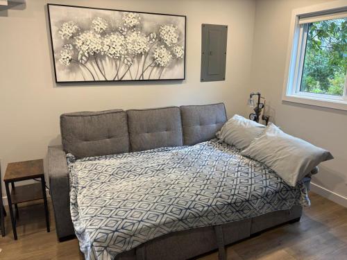 Un dormitorio con una cama y un cuadro en la pared. en Cozy 1-Bedroom Retreat in the Heart of Langford, en Victoria