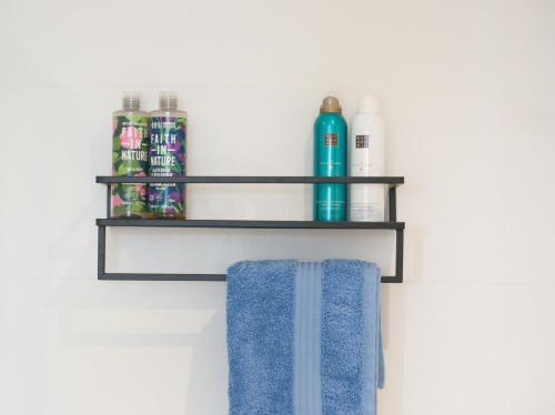 a bathroom shelf with two bottles and a blue towel at Petralia BnB in Portland