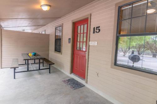 una porta rossa in una stanza con un tavolo e una panca di Frio Country #15 a Concan