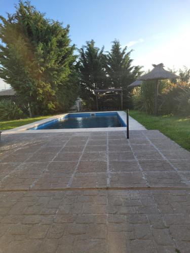 una piscina in un cortile con patio in pietra di Finca131 a Necochea