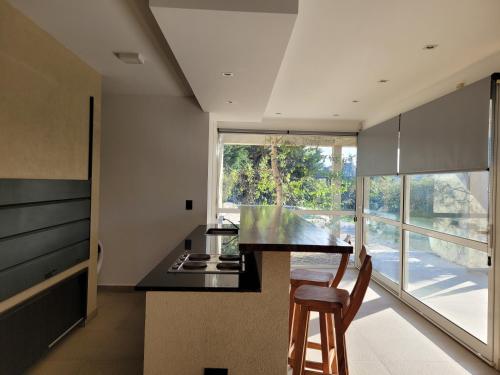 una cucina con un bancone, un tavolo e delle sedie di Finca131 a Necochea