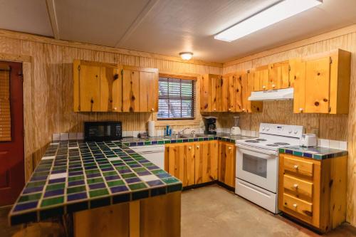 una cucina con armadi in legno e un piano cottura bianco con forno di Frio Country #21 a Concan