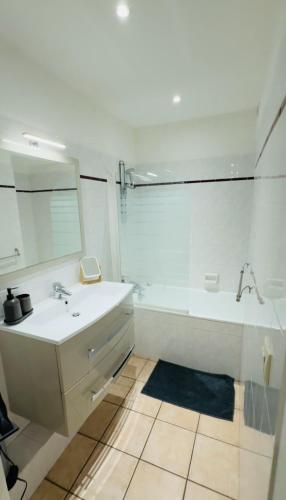 a white bathroom with a sink and a shower at Appartement cosy proche métro Cusset in Villeurbanne