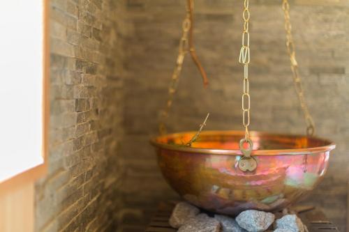 a bowl hanging from a chain in a brick wall at Großplonerhof in Luson