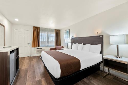 a hotel room with a large bed and a desk at Americas Best Value Inn and Suites Flagstaff in Flagstaff