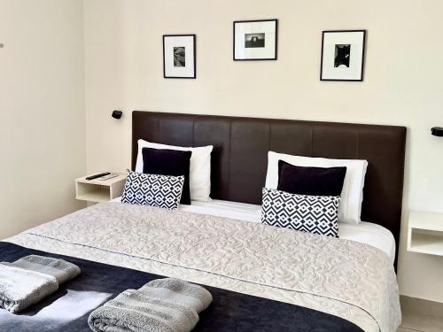 a bedroom with a large bed with black and white pillows at Studio Conexión Mendoza WiFi rápido cerca del Parque San Martín y Av Arístides in Godoy Cruz