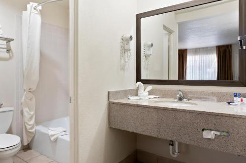 a bathroom with a sink and a toilet and a mirror at Americas Best Value Inn and Suites Flagstaff in Flagstaff