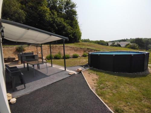 eine Terrasse mit einem Zelt, einem Tisch und einem Picknicktisch in der Unterkunft Maison plain-pied au calme proche lac de miel Wifi gratuit in Beynat