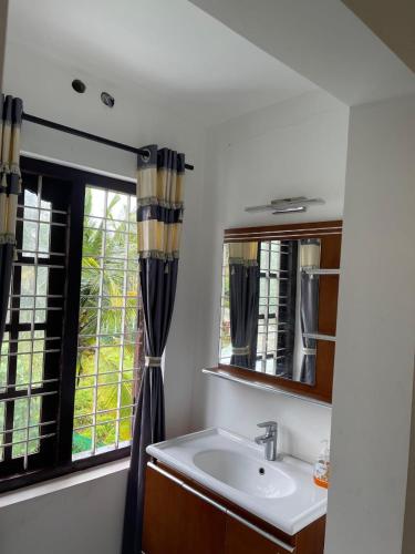 a bathroom with a sink and a window at Wayanad Midnight Oasis in Meenangadi