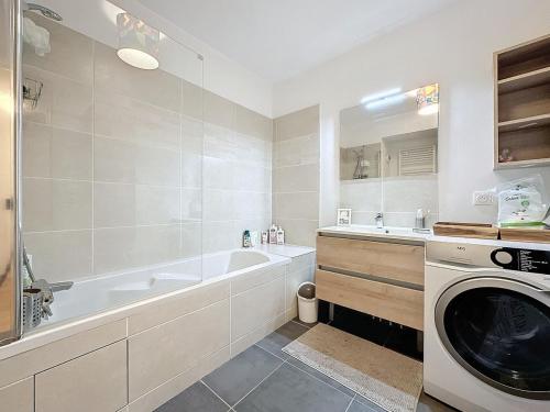 a bathroom with a tub and a washing machine at Classy apartment with terrace in Saint-Ouen