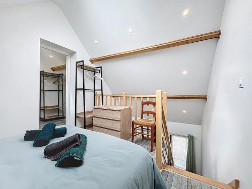 a bedroom with a large bed and a staircase at Maisonnette 36m2 à 5 minutes de Chantilly in Vineuil-Saint-Firmin