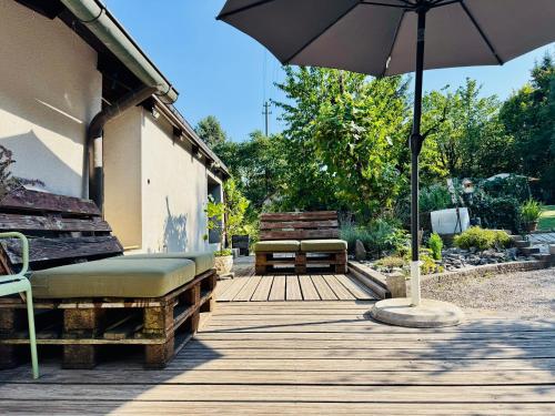 an umbrella and a bench on a wooden deck at Sabes Ferienwohnung in Altglandorf