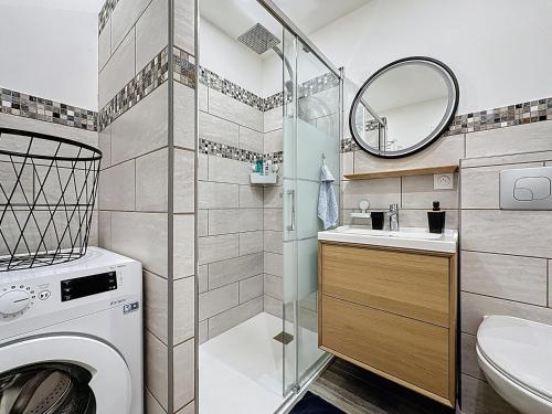 a bathroom with a sink and a washing machine at Maisonnette 36m2 à 5 minutes de Chantilly in Vineuil-Saint-Firmin