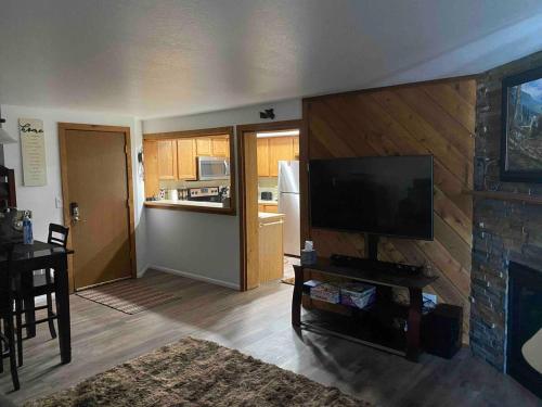 een woonkamer met een flatscreen-tv en een open haard bij Cozy Bear Condo in Brian Head