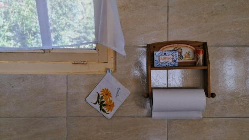 a bathroom with a window and a roll of toilet paper at La Casita del Molino in Trevelin
