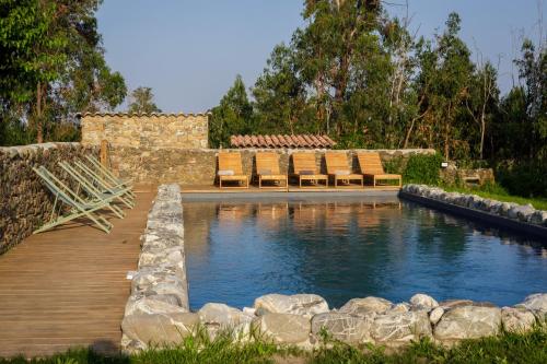 une piscine avec des chaises et une terrasse en bois dans l'établissement Suite du Domaine Marquiliani, à Fautea