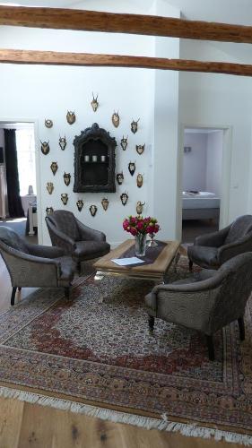 a living room with two chairs and a table and a fireplace at Herrenhaus Gut Neuruppersdorf in Timmendorfer Strand