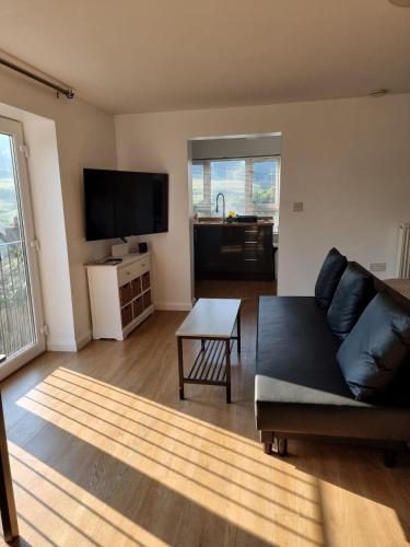 a living room with a couch and a flat screen tv at Rock Ridge Villa in Abertillery