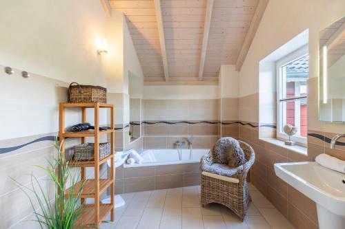 a bathroom with a tub and a sink at Schimmelreiter in Struckum