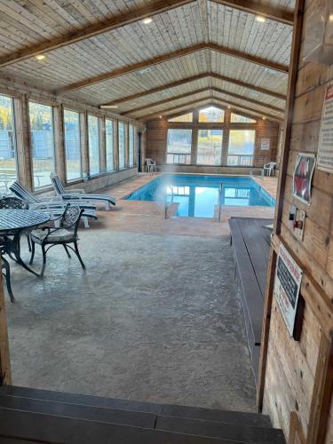 a swimming pool with tables and chairs in a building at Cozy Bear Condo in Brian Head