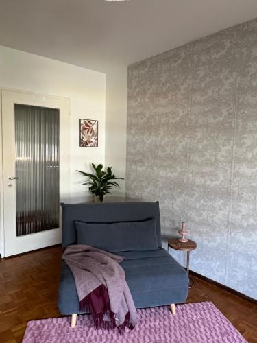 a living room with a blue couch and a pink rug at Champel Cozy Studio in Geneva